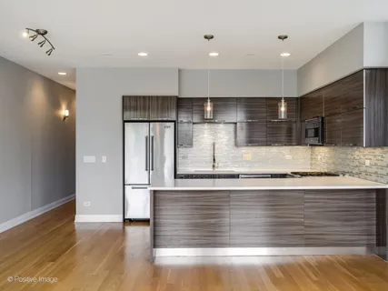 a view of a kitchen with stainless steel appliances granite countertop a stove and a refrigerator