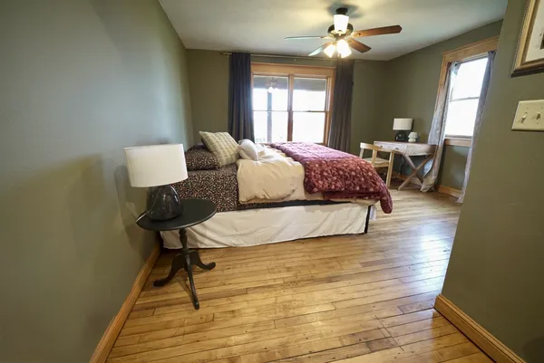 a living room with a bed furniture chandelier and a window