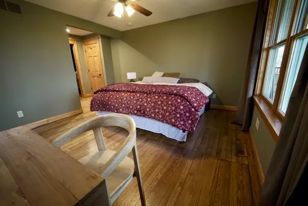 a bedroom with a bed and wooden floor