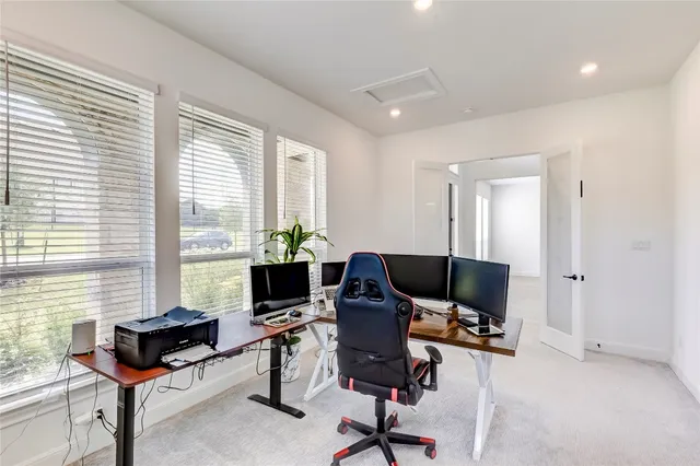 a view of a workspace with furniture and a window