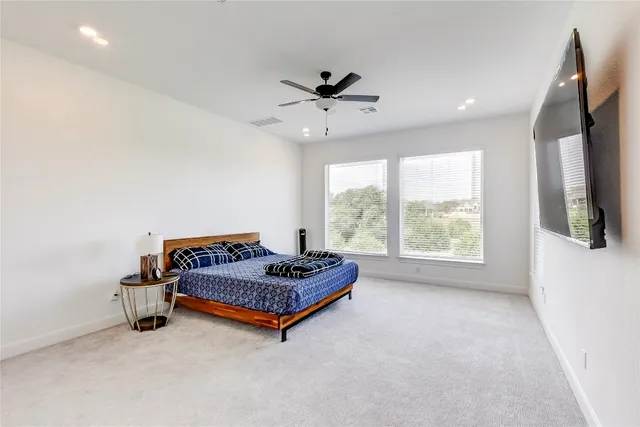 a bedroom with bed and ceiling fan