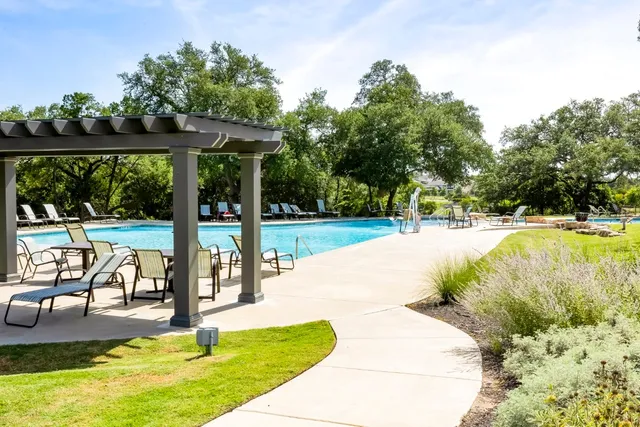 a view of a swimming pool with a table and chairs under an umbrella