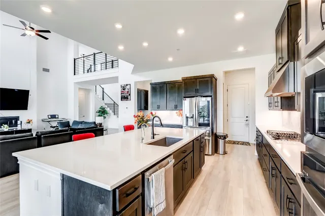 a kitchen that has a lot of cabinets a sink and wooden floor
