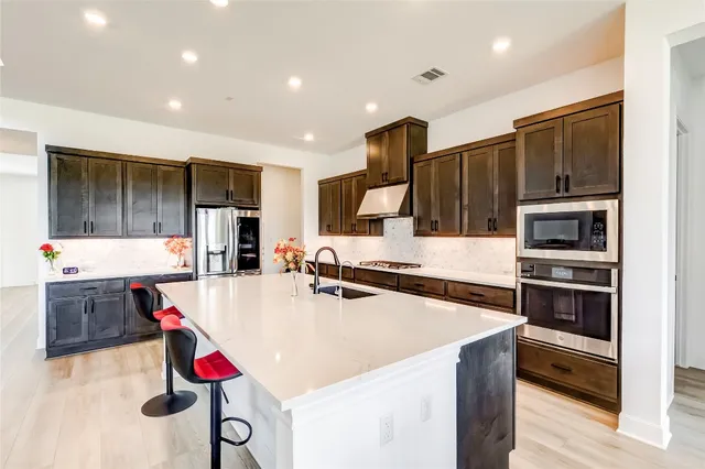 a kitchen with stainless steel appliances a sink and a refrigerator