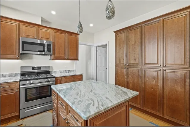 a kitchen with stainless steel appliances granite countertop a stove top oven a sink and a microwave