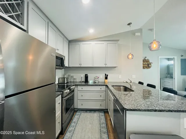 a kitchen with a sink a refrigerator and a stove