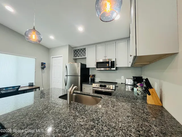 a kitchen with stainless steel appliances granite countertop a sink a stove and a refrigerator