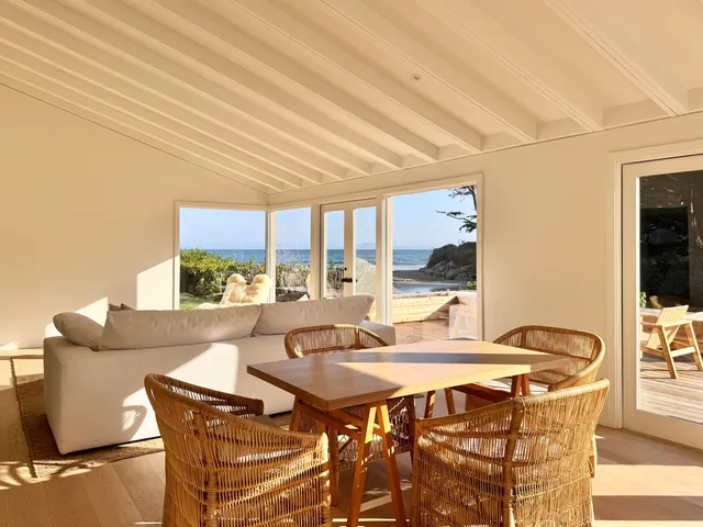 a living room with furniture a large window and a table