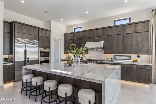 a kitchen with stainless steel appliances granite countertop a sink and a stove