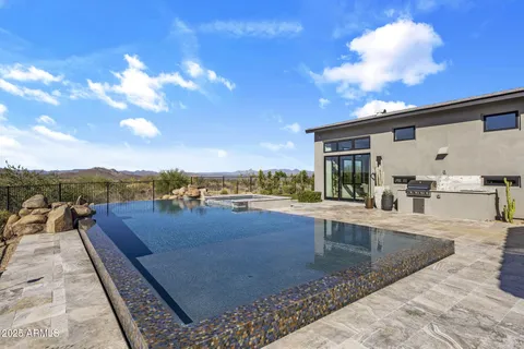 a living room with stainless steel appliances granite countertop a table chairs and a wooden floor