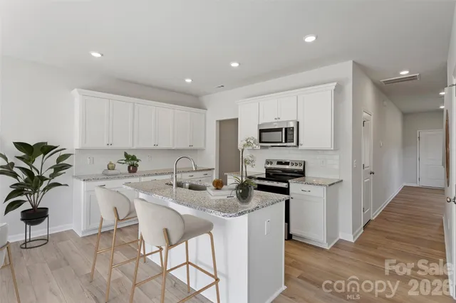 a kitchen with stainless steel appliances granite countertop a stove a sink a refrigerator and a granite counter tops
