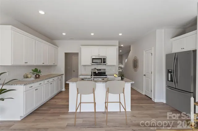 a kitchen with granite countertop a center island stainless steel appliances and cabinets