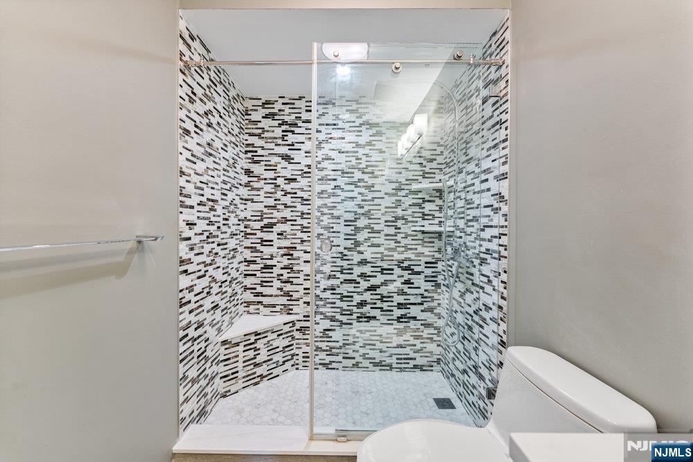 160 Overlook Avenue, Unit 20D Hackensack, NJ 07601 - Photo 12 of 22 a bathroom with a toilet and a shower curtain