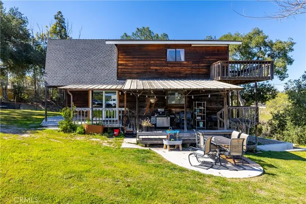 a view of a swimming pool with lawn chairs and a big yard