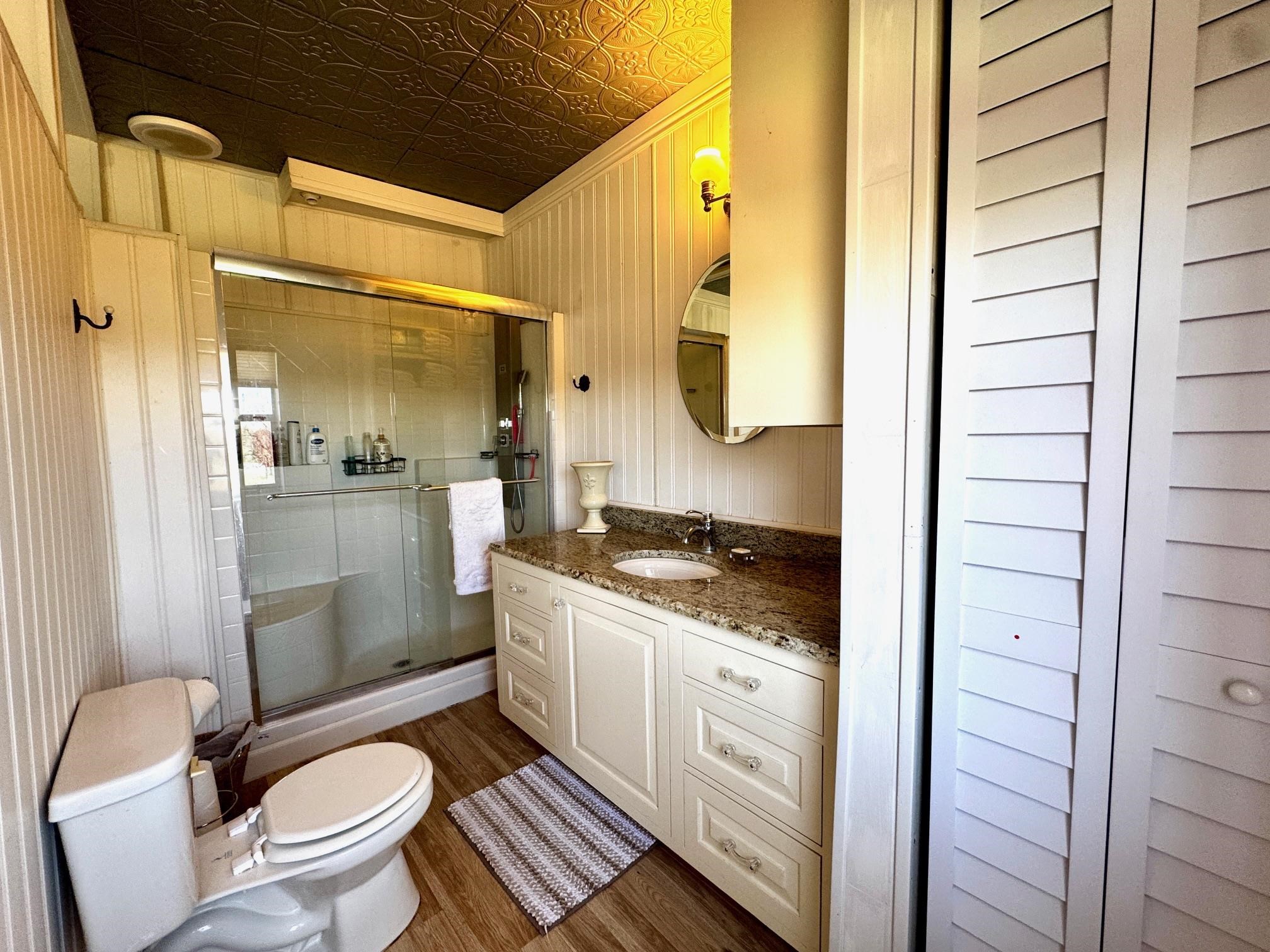 6410 Gray Road Valley Spring, TX 76885 - Photo 18 of 31 a bathroom with a granite countertop sink toilet and shower