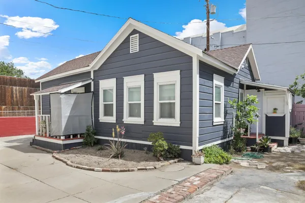 a view of a house with a yard and tree
