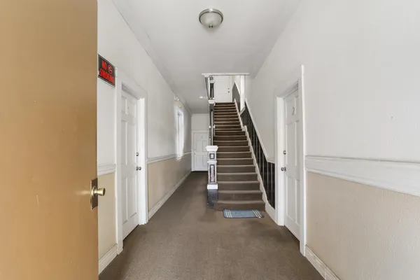 a view of a hallway with wooden floor and entryway