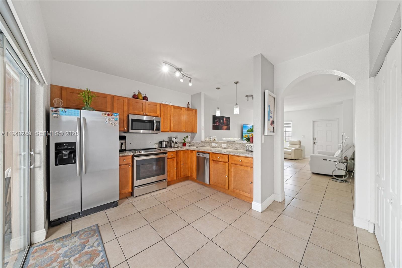 13770 Southwest 170th Lane Miami, FL 33177 - Photo 9 of 24 a kitchen with granite countertop a refrigerator and white cabinets