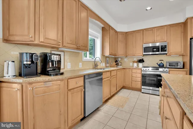 a kitchen with stainless steel appliances granite countertop a sink and dishwasher a refrigerator with white cabinets
