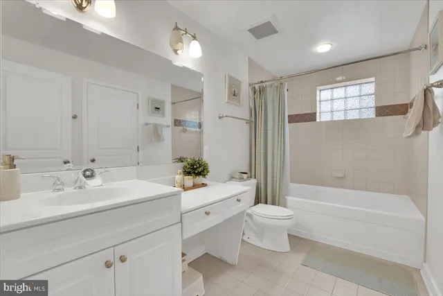 a bathroom with a double vanity sink toilet and shower