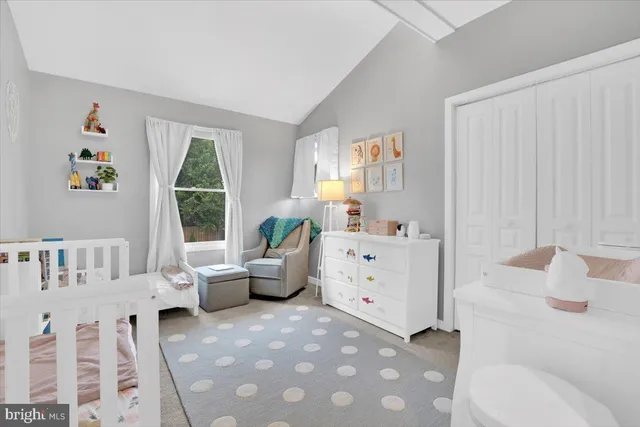 a bedroom with a bed and a flat tv screen on dresser