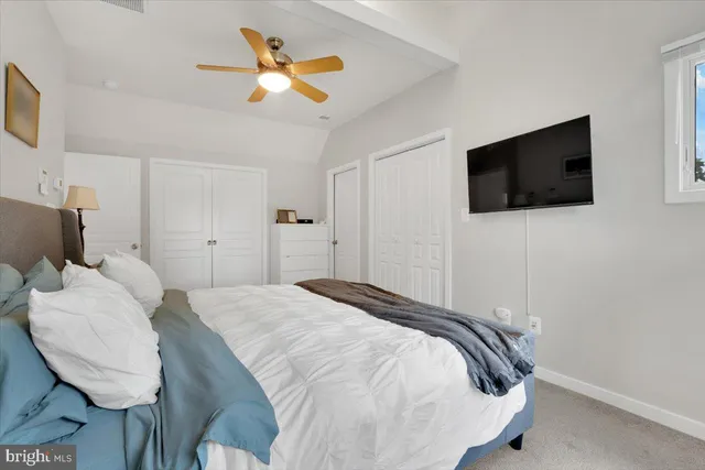 a spacious bedroom with a bed and a flat screen tv