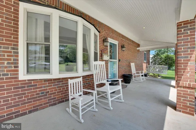 a porch area with table and chairs