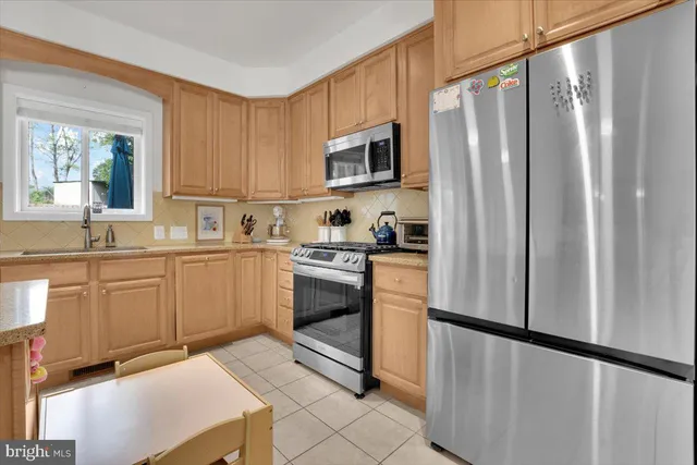 a kitchen with stainless steel appliances a refrigerator sink and microwave