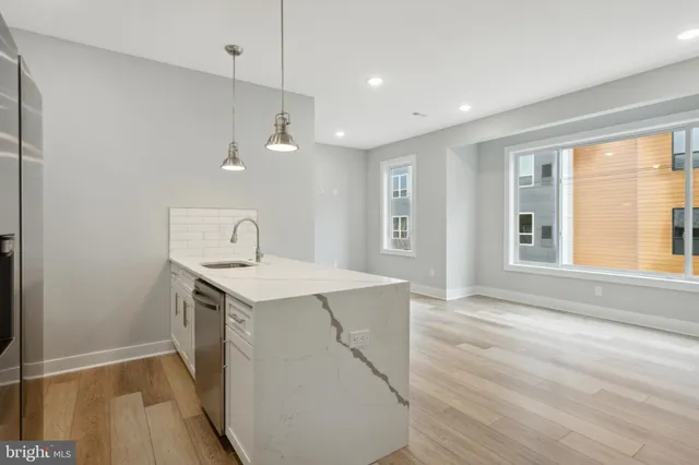 a view of a kitchen with a stove wooden floor and a window