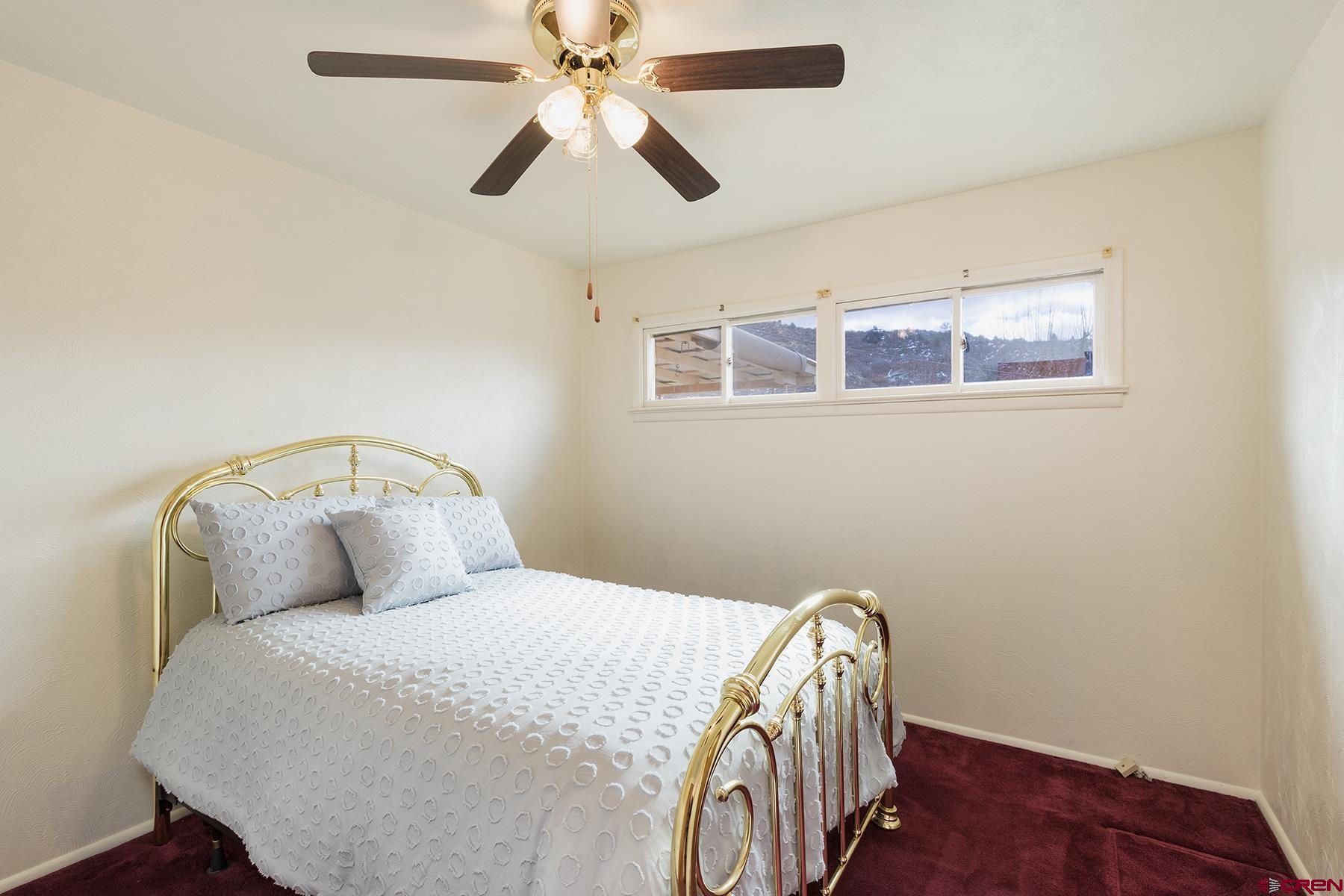 164 Riverview Drive Durango, CO 81301 - Photo 15 of 32 a bedroom with a bed and a chandelier