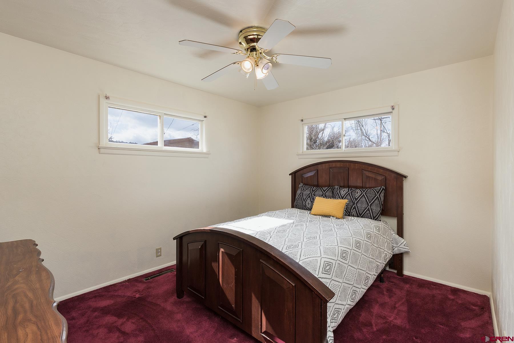 164 Riverview Drive Durango, CO 81301 - Photo 17 of 32 a bedroom with a bed and a chandelier