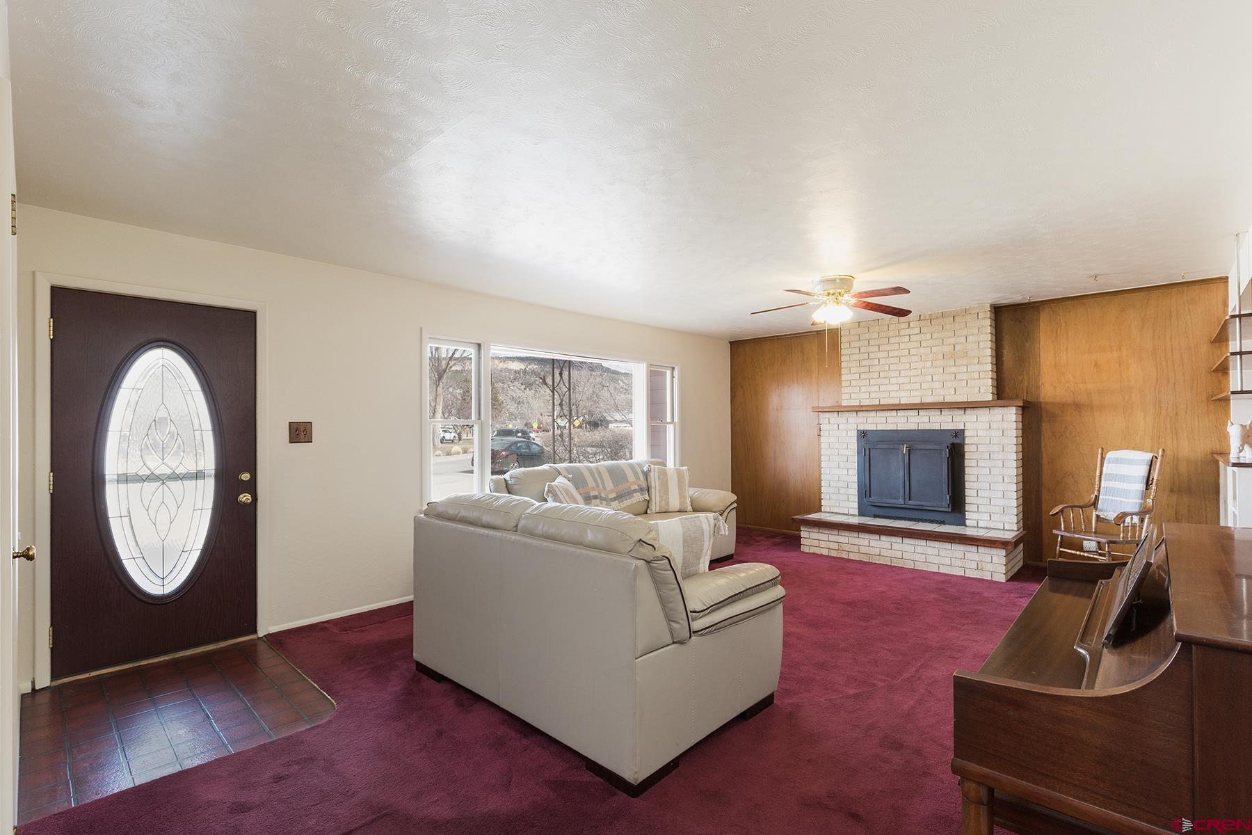 164 Riverview Drive Durango, CO 81301 - Photo 4 of 32 a living room with furniture a fireplace and a flat screen tv