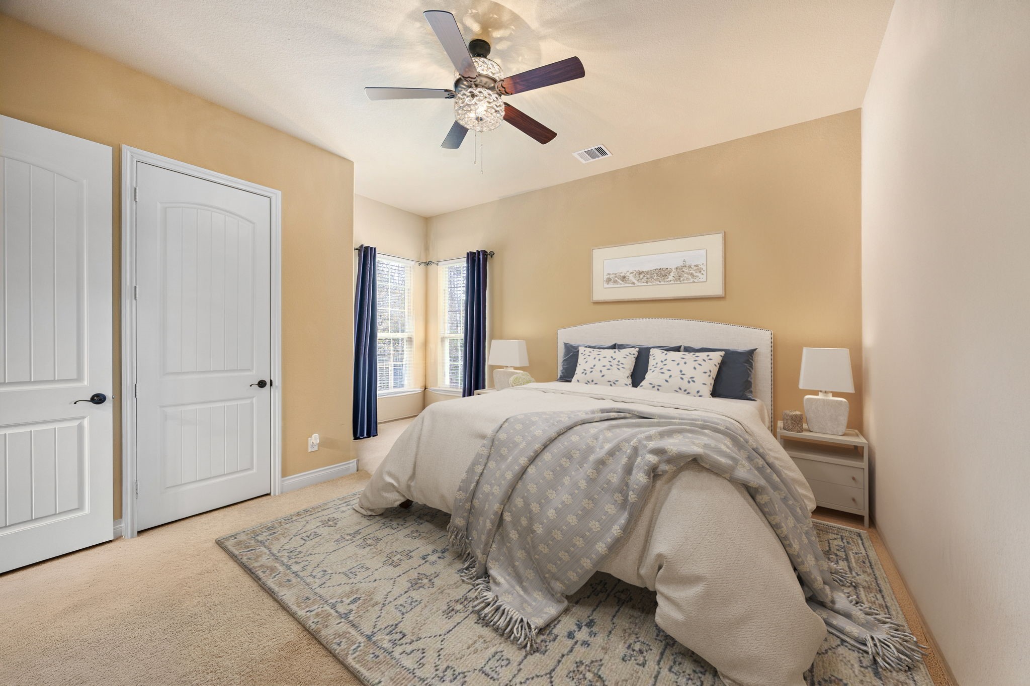 23421 Cannondale Loop Montgomery, TX 77316 - Photo 22 of 47 Beautifully styled secondary bedroom downstairs offering plush carpeting, warm neutral tones, and a soft, inviting atmosphere. Features include a ceiling fan with decorative light fixture, cozy bedding, and large windows dressed with elegant curtains that bring in natural light. A perfect space for guests, family, or a comfortable home office setup.