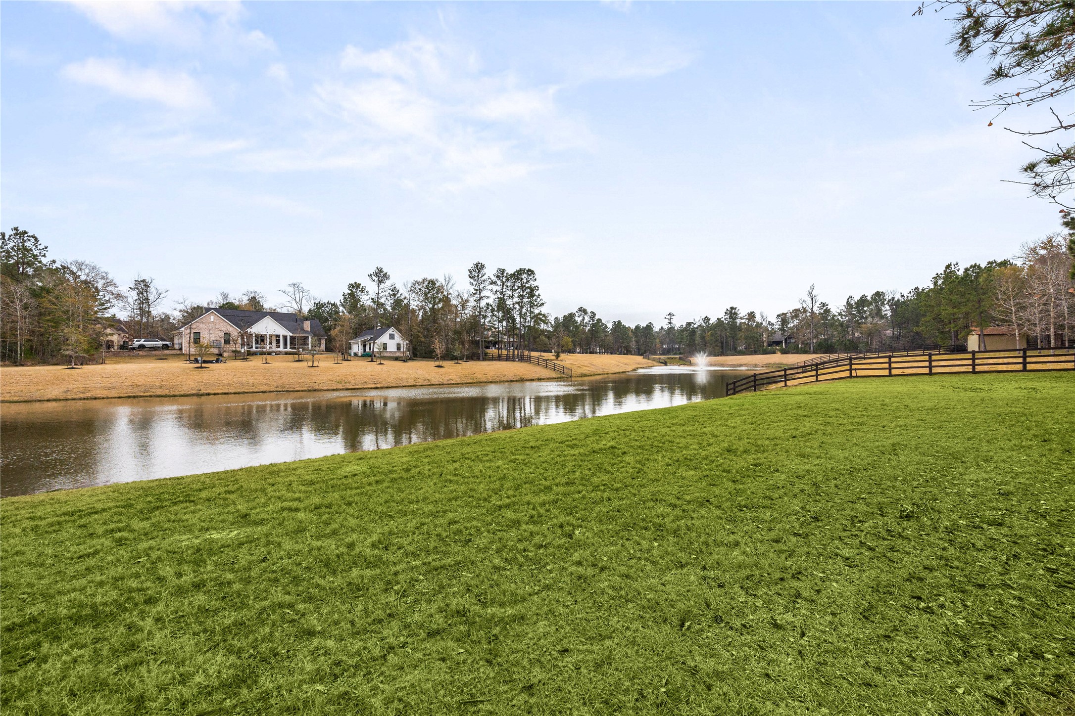 23421 Cannondale Loop Montgomery, TX 77316 - Photo 38 of 47 Beautiful water view with gently sloping green space leading to a tranquil pond, offering a picturesque setting and peaceful atmosphere. The open landscape, surrounding homes, and distant fountain create a scenic backdrop—ideal for enjoying nature, morning coffee, or evening sunsets right from your backyard.