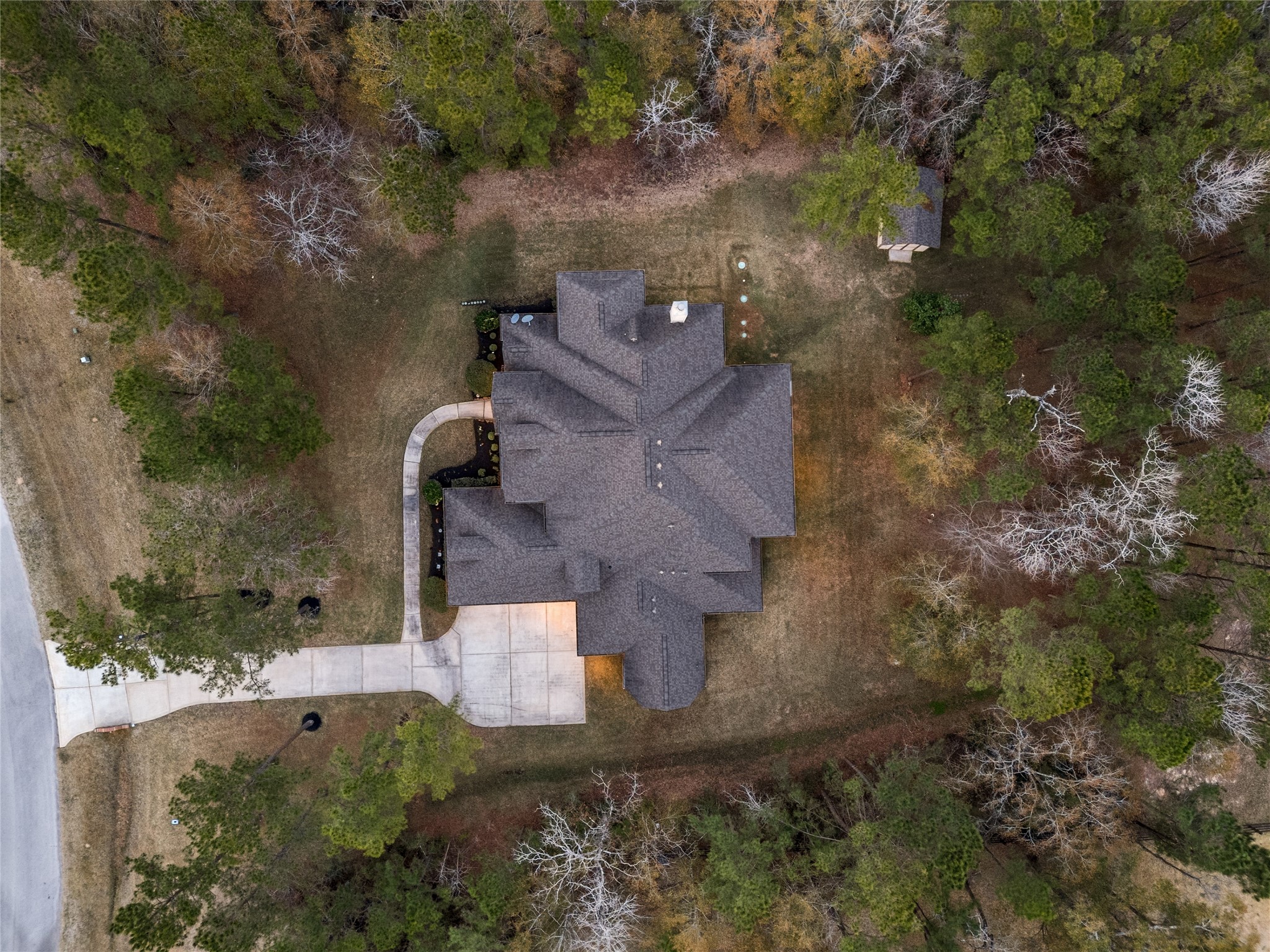 23421 Cannondale Loop Montgomery, TX 77316 - Photo 39 of 47 Aerial view showcasing the home’s footprint and its placement on a generously sized, tree-lined lot. Surrounded by mature trees that provide privacy and a natural buffer, the property offers a peaceful setting with ample yard space and a well-defined driveway approach—highlighting both space and seclusion.