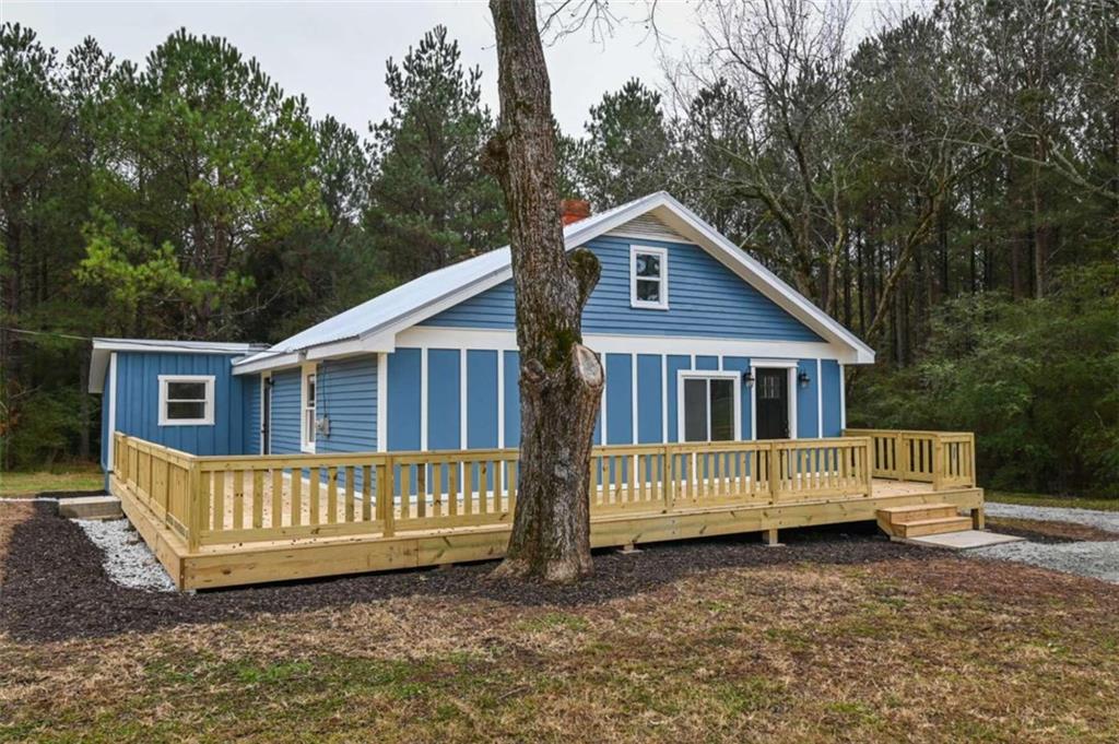 3260 7 Island Road Monticello, GA 31064 - Photo 1 of 1 a view of a house with a yard and deck in the forest