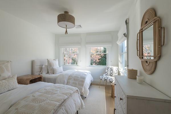 520 Hampton Road, Unit 18 Southampton, NY 11968 - Photo 13 of 20 a bedroom with a bed a mirror and a large window