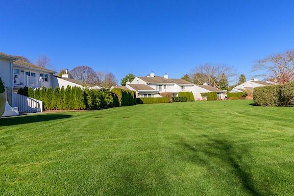 520 Hampton Road, Unit 18 Southampton, NY 11968 - Photo 20 of 20 a view of a grassy field with an trees