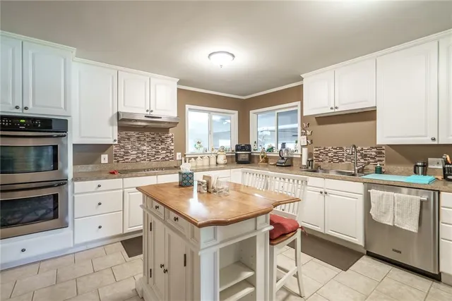a kitchen with a sink a refrigerator and cabinets