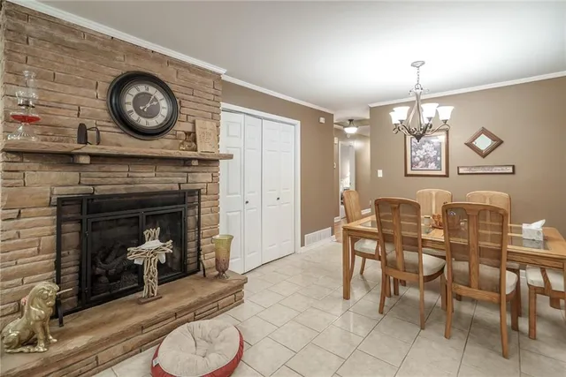 a dining room with wooden floor a chandelier a wooden table and chairs