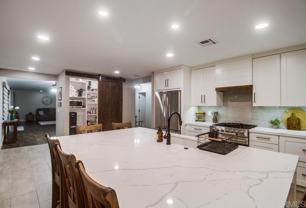 2444 Via Dieguenos Alpine, CA 91901 - Photo 12 of 69 a kitchen with stainless steel appliances kitchen island granite countertop a refrigerator a stove a sink a dining table and chairs