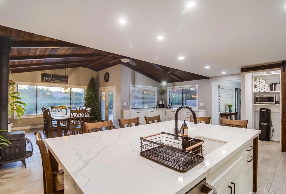 2444 Via Dieguenos Alpine, CA 91901 - Photo 22 of 69 a kitchen with stainless steel appliances granite countertop a table chairs and a wooden floor