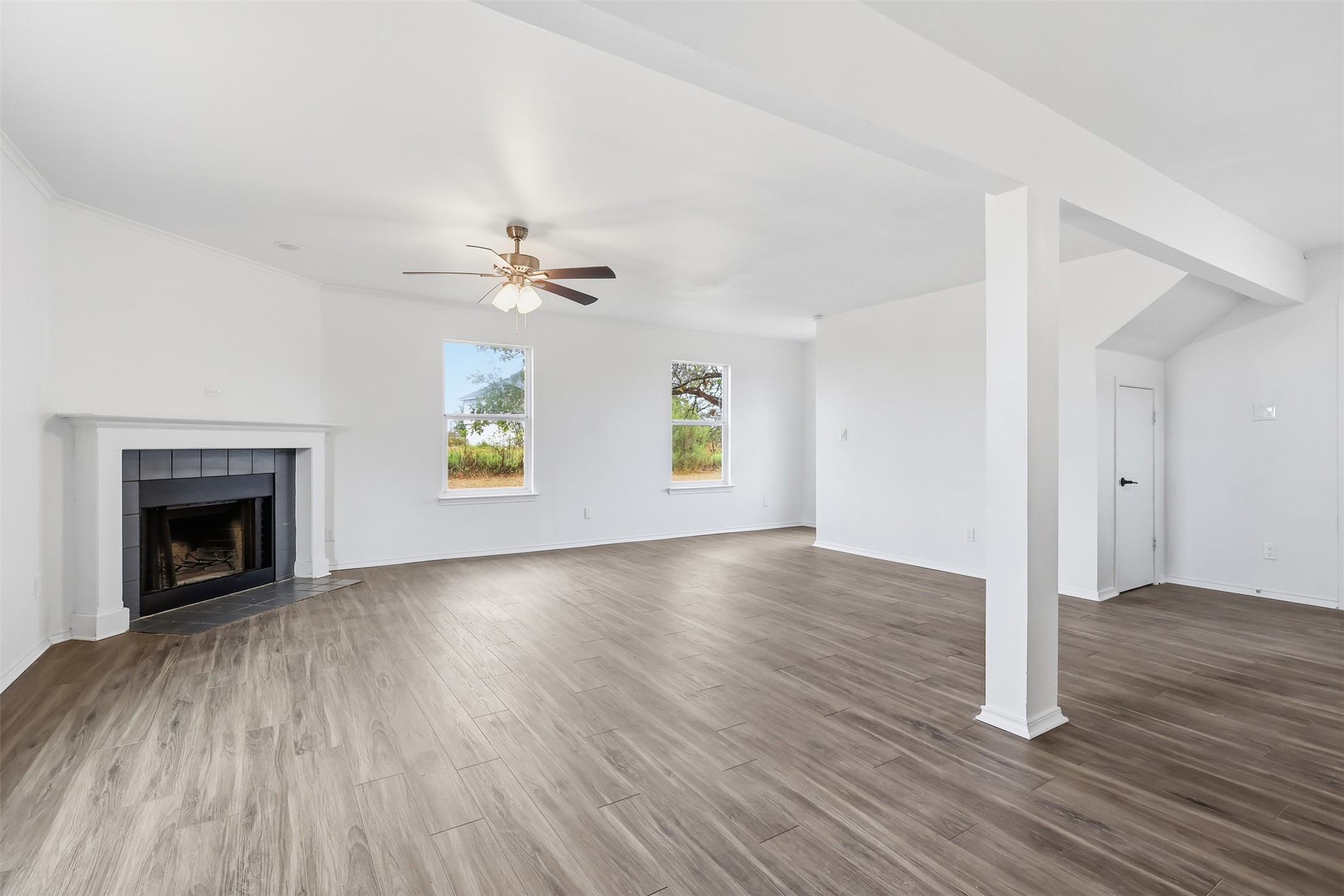 13201 Jacobson Road Manor, TX 78653 - Photo 11 of 25 an empty room with wooden floor fireplace and windows
