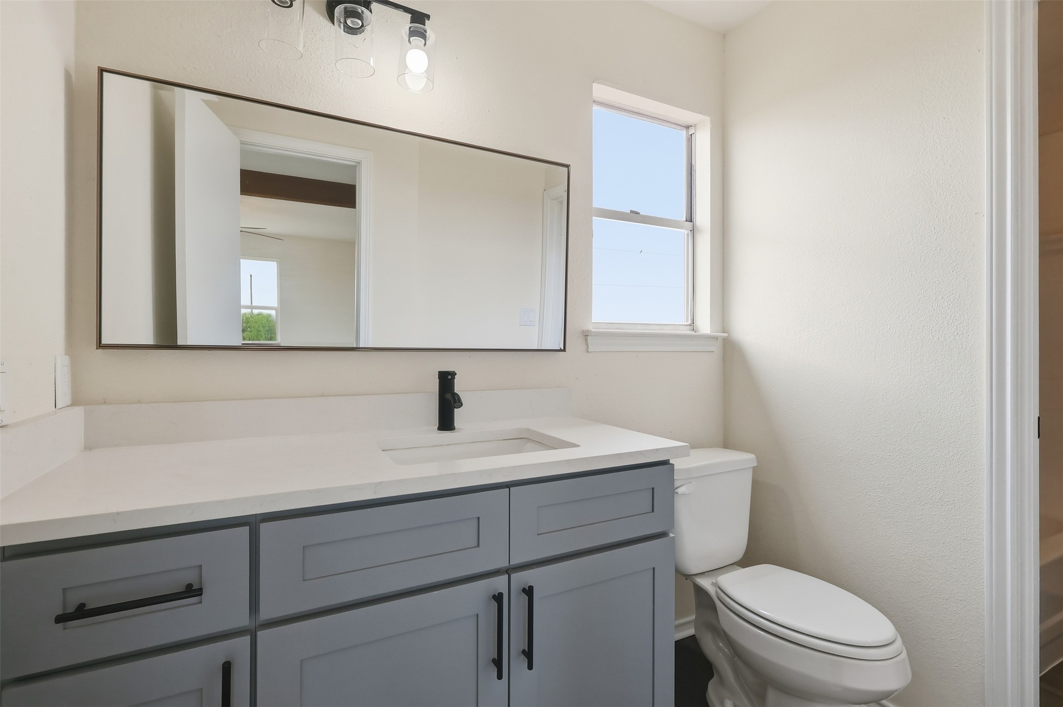 13201 Jacobson Road Manor, TX 78653 - Photo 16 of 25 a bathroom with a toilet sink vanity and mirror