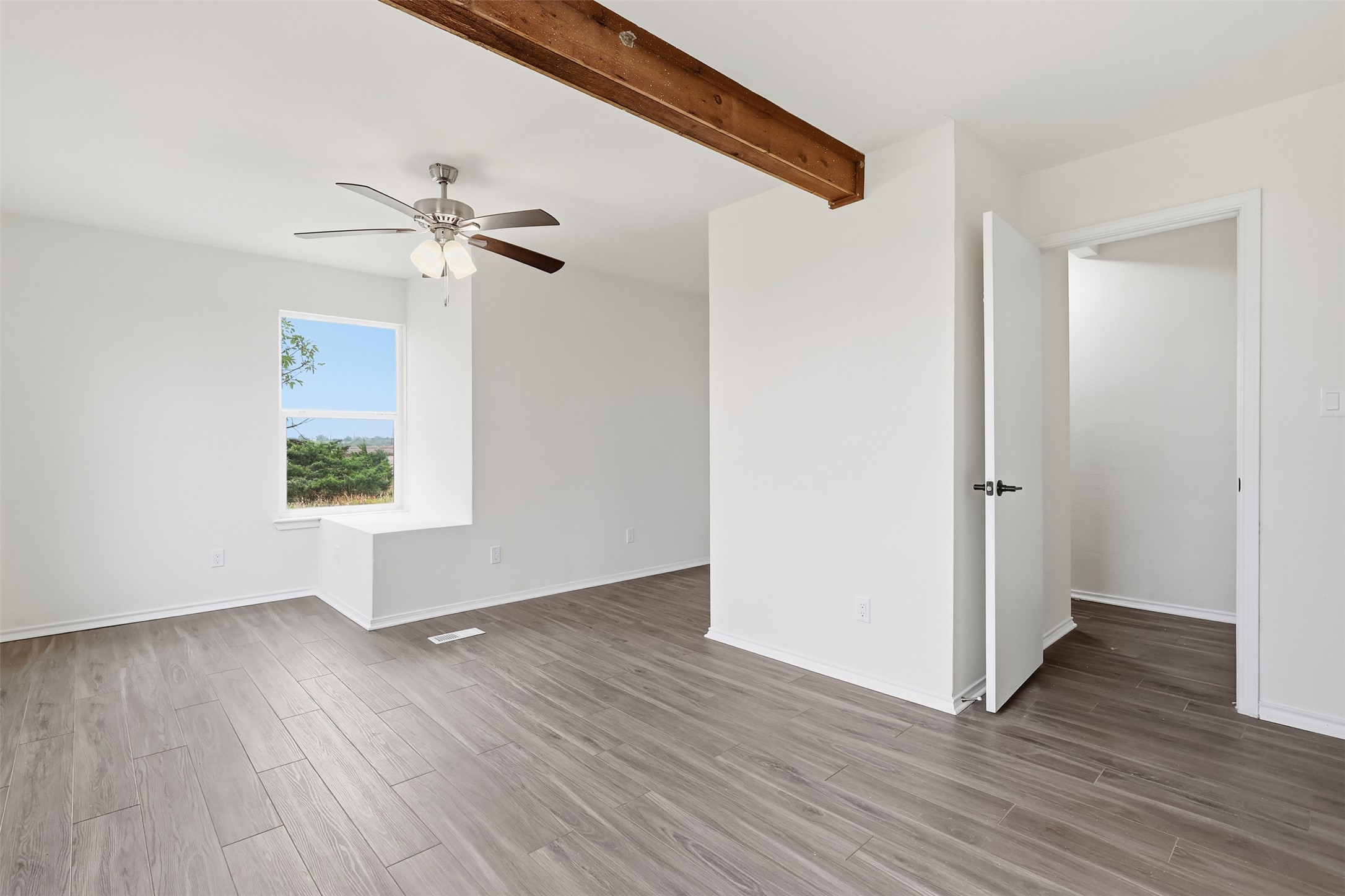 13201 Jacobson Road Manor, TX 78653 - Photo 19 of 25 an empty room with wooden floor chandelier fan and windows