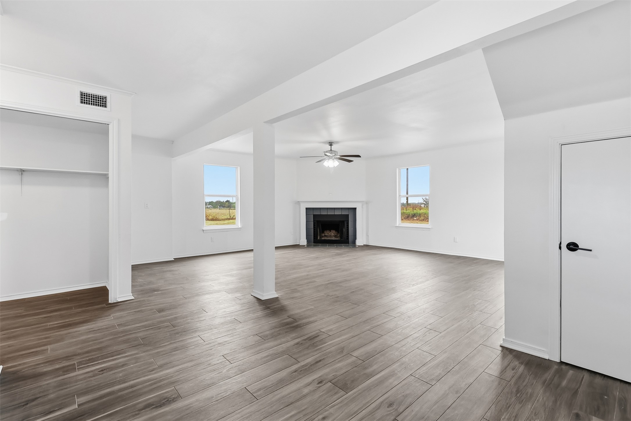 13201 Jacobson Road Manor, TX 78653 - Photo 8 of 25 an empty room with wooden floor fireplace and windows