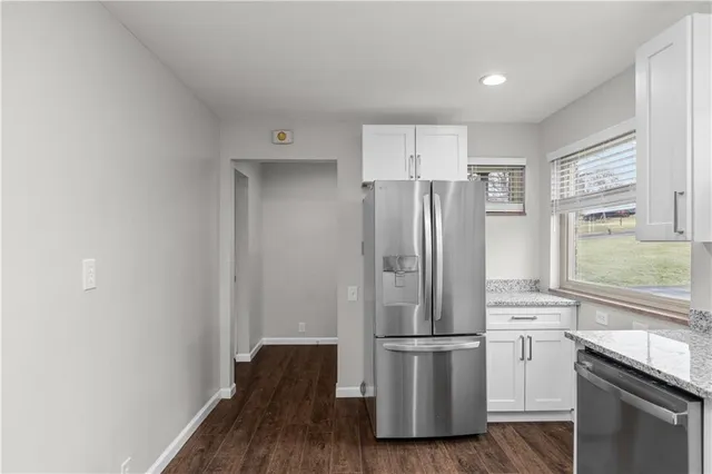 a kitchen with a refrigerator and a stove top oven