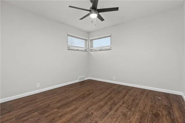 a view of a room with wooden floor and ceiling fan