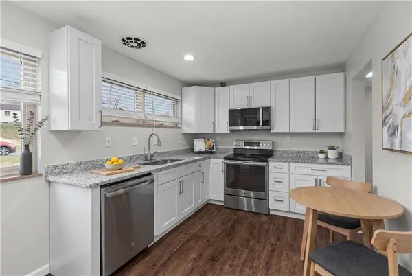 a kitchen with a sink stove a sink and dishwasher a refrigerator with wooden floor