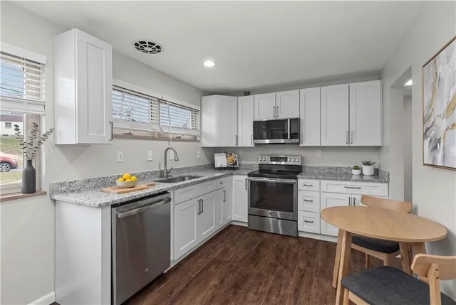 a kitchen with a sink stove a sink and dishwasher a refrigerator with wooden floor